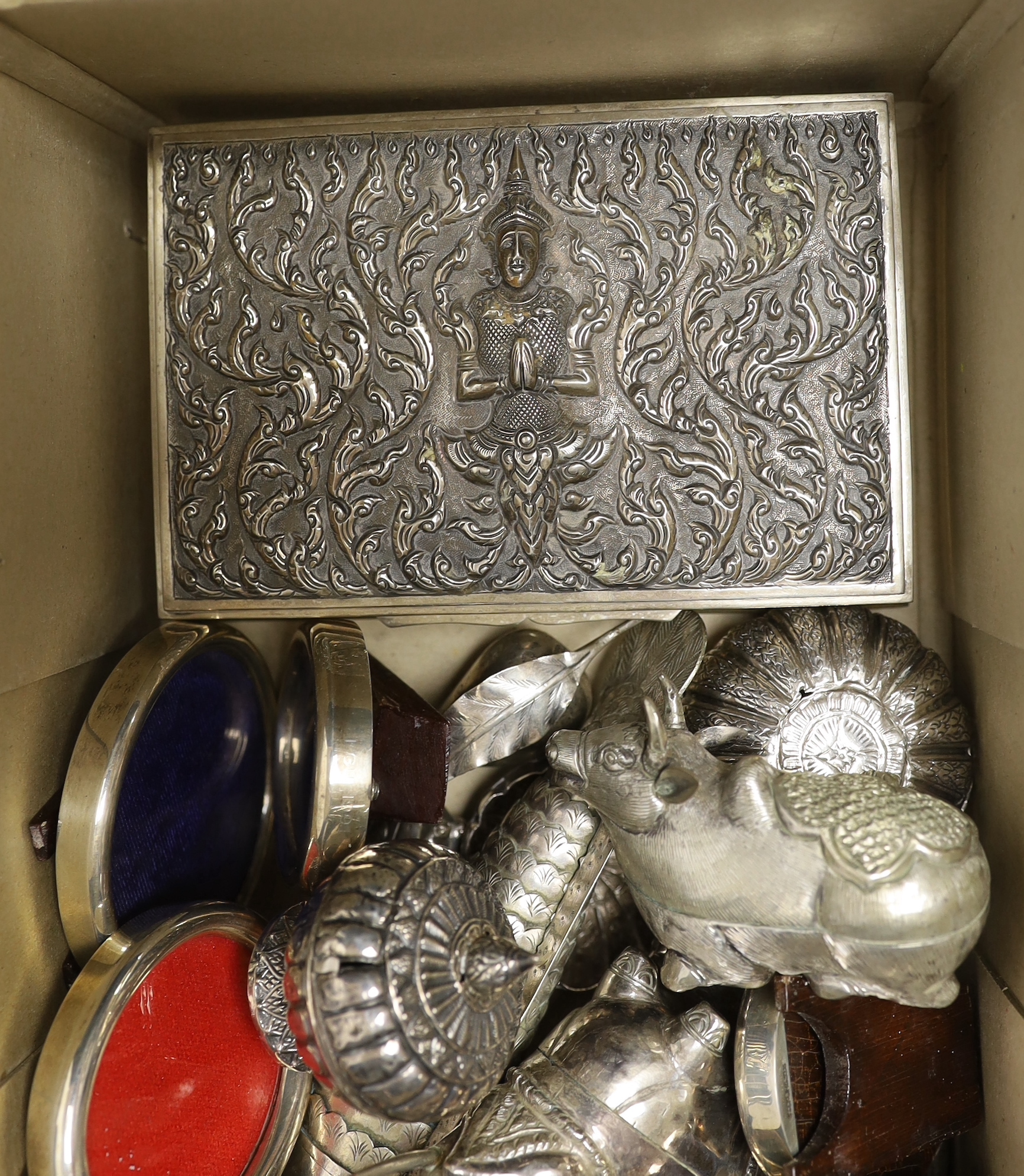 Sixteen assorted sterling mounted small photograph frames, largest 88mm and a quantity of assorted Thai boxes, mainly modelled as birds and other animals, a Thai repousse sterling cannister and cover and a Thai sterling